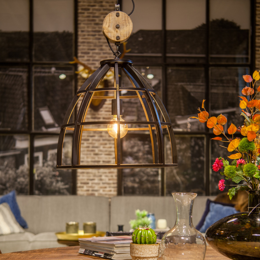 Sfeervolle woonkamer met ruige hanglamp van burned steel met katrol erboven